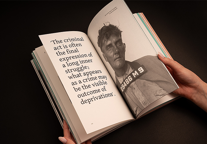 .The left page features an English quote, while the right page shows a black-and-white mugshot of a man holding an identification number board
