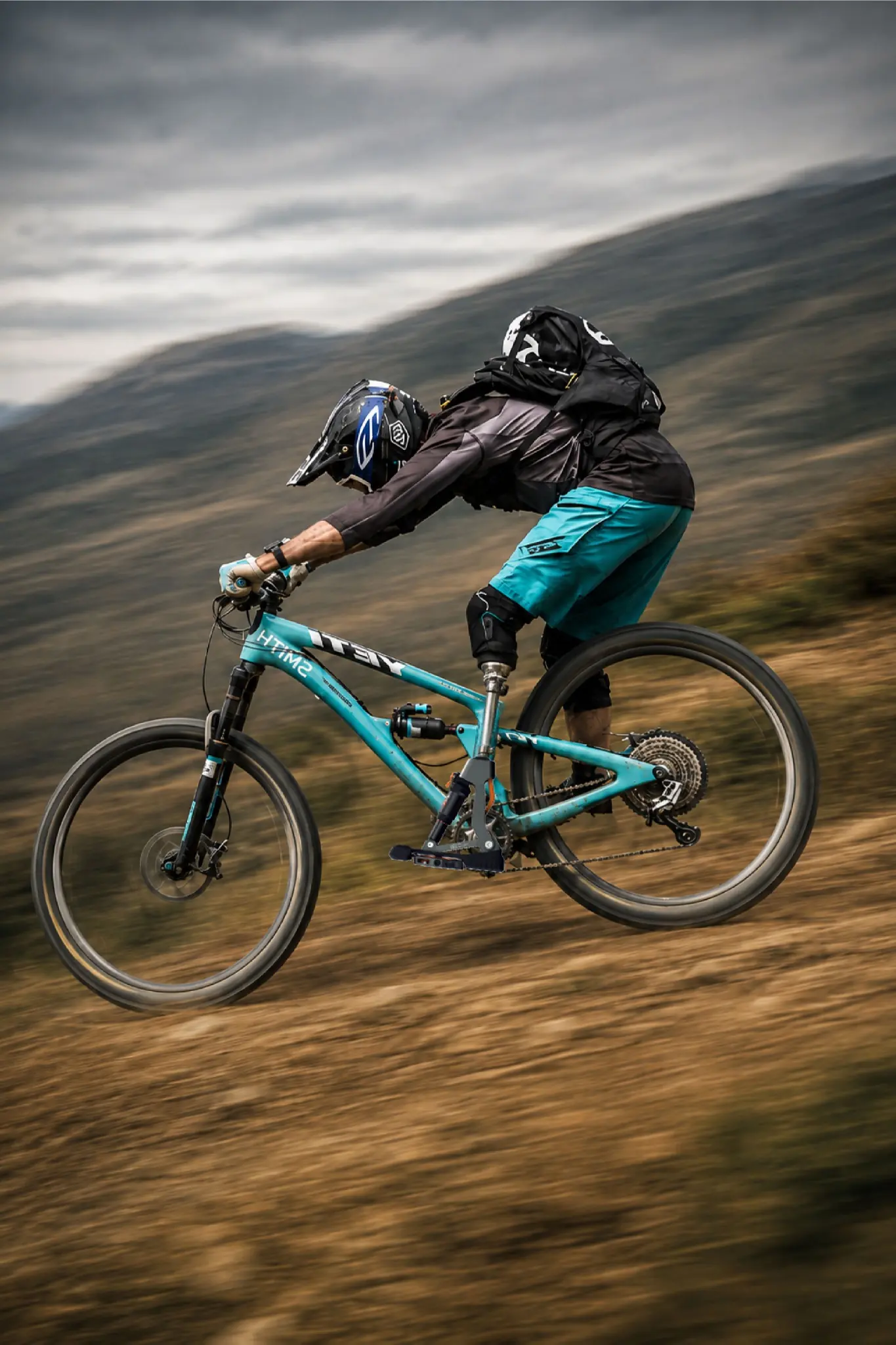 A cyclist uses the pedal and prosthesis while riding off-road.